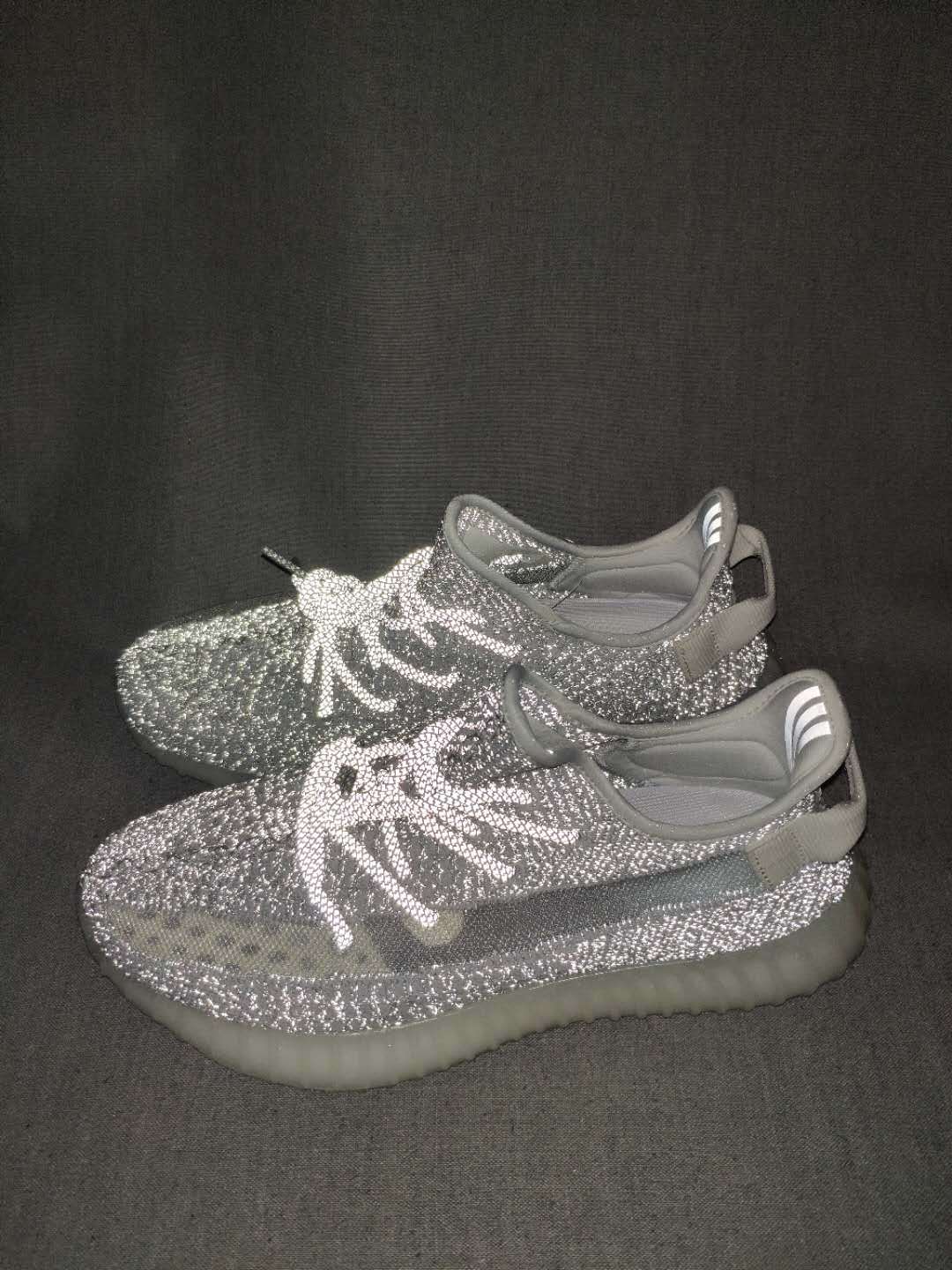 Pair of silver-gray knit sneakers shown from an angled front view with translucent ribbed soles.