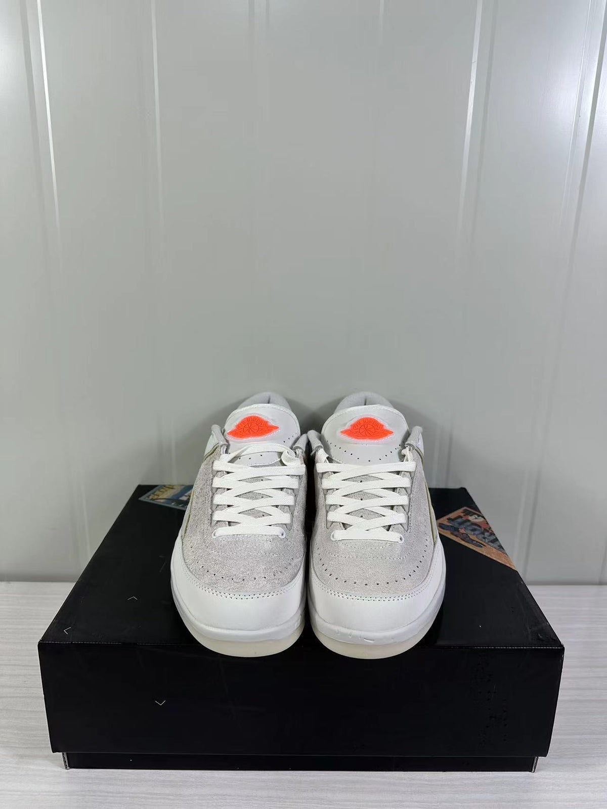 Front view of the pair showing tonal laces, perforated toe panels, and orange tongue logos.
