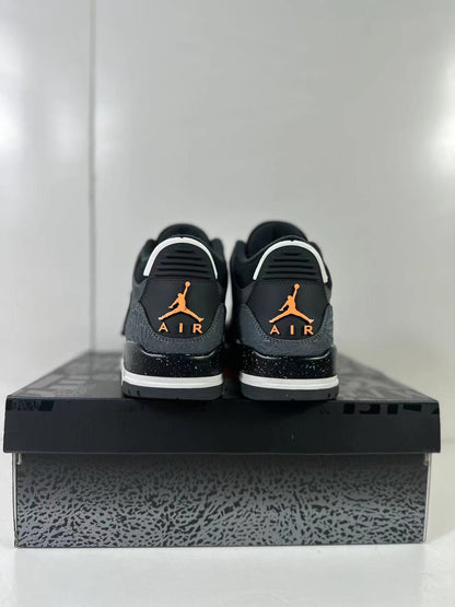 Rear view of the pair showing orange Jumpman and AIR branding, black-speckled midsoles, and elephant-print heel panels.