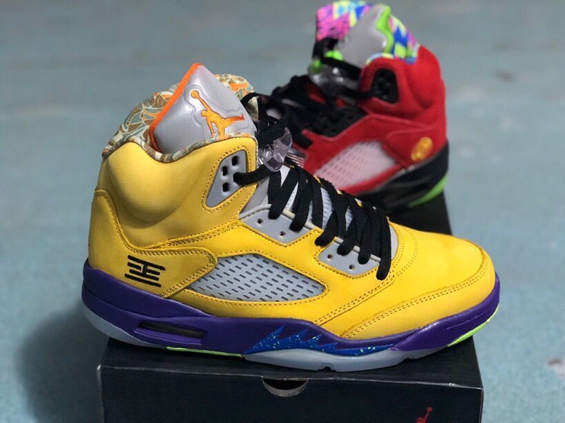 Yellow high-top sneaker shown from the side with purple accents, mesh panel, black laces, and translucent outsole details.