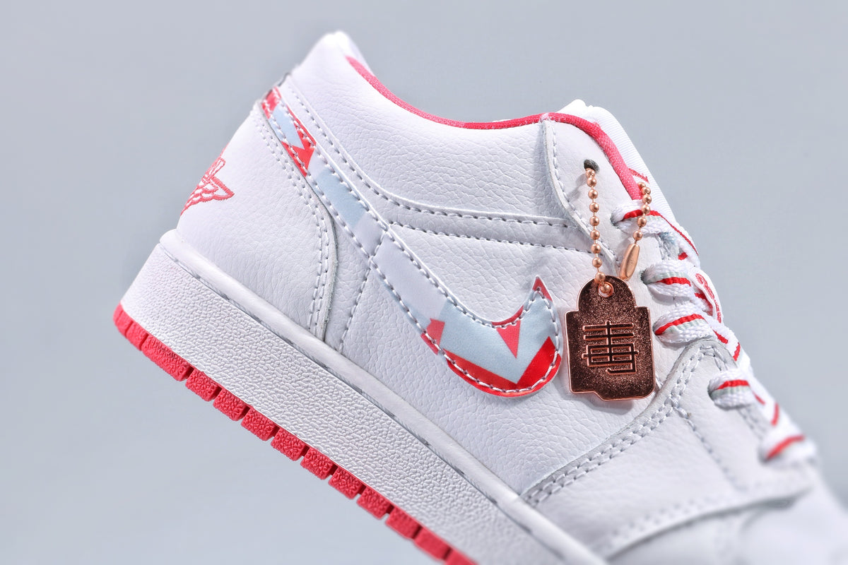 Close-up of the white textured upper, patterned side swoosh, contrast stitching, and attached decorative tag.