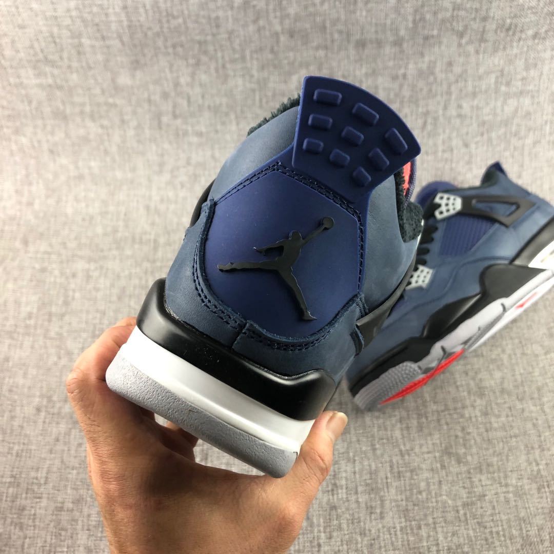 Close rear three-quarter view showing the navy heel panel, black emblem, and layered midsole.