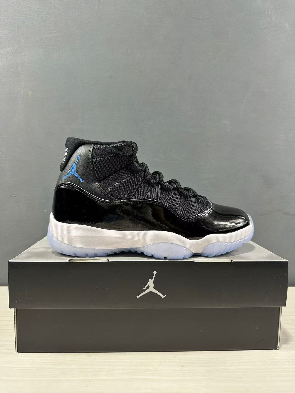 Side profile of a single black and blue high-top sneaker placed on a Jordan shoebox.
