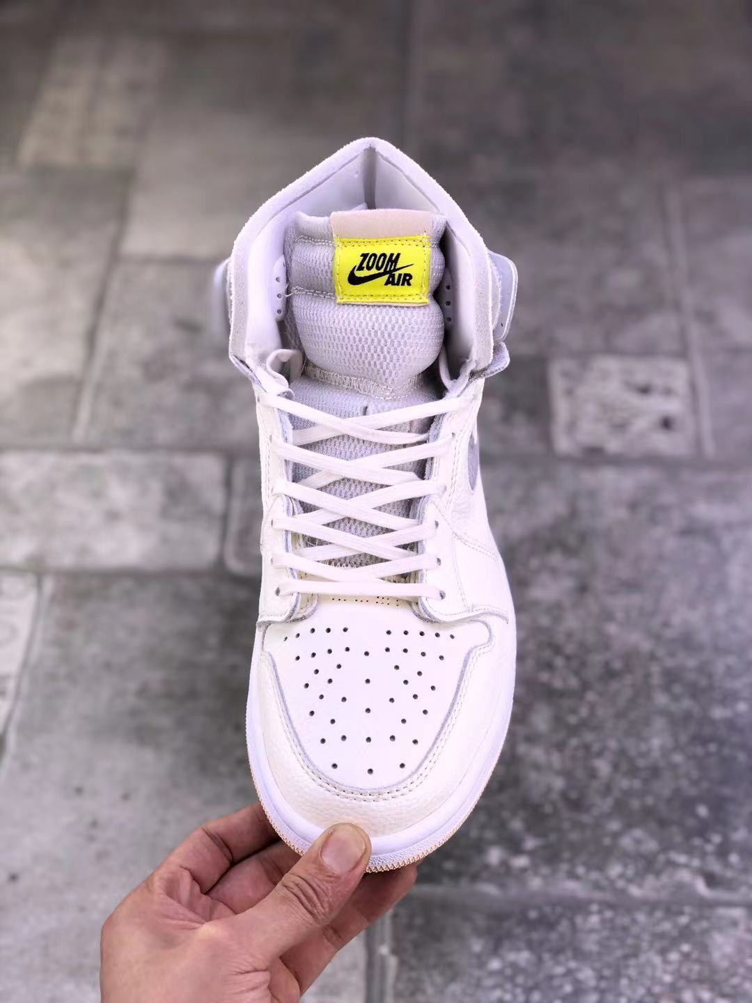 Top-down view of the sneaker showing the white lacing system, perforated toe box, and yellow Zoom Air tongue label.