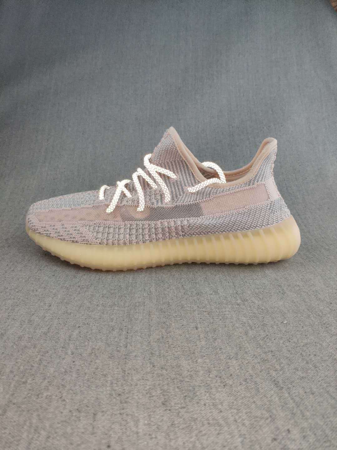 Side profile of a grey and pink-toned Yeezy 350 V2 style sneaker with a ribbed translucent gum-colored sole.