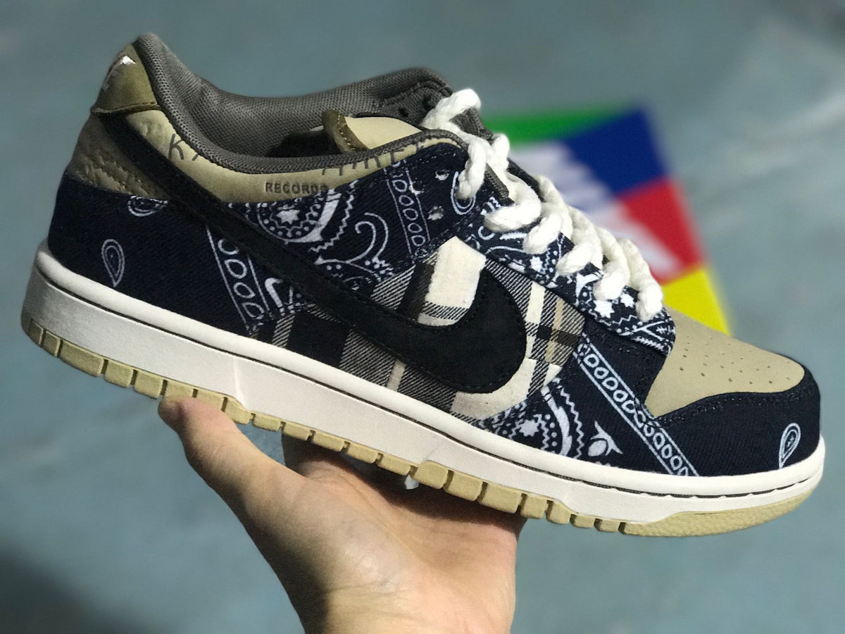Three-quarter product view showing the black patterned upper, plaid side panel, dark Swoosh, light laces, and beige toe box.