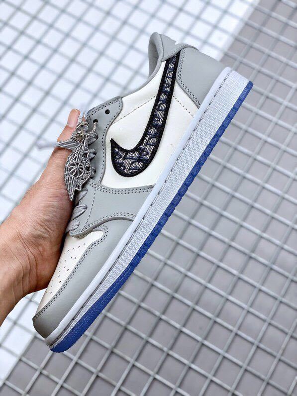 Side close-up showing the patterned black Swoosh, grey overlays, white midsole, and blue outsole.