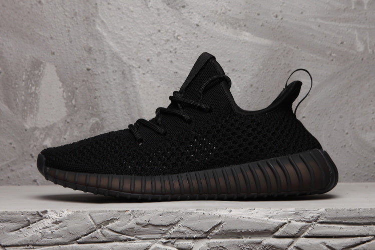 Side profile of the black sneaker with a textured upper, heel pull tab, and ribbed sole.