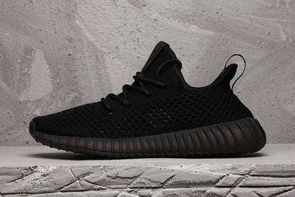Side profile of the black sneaker with a textured upper, heel pull tab, and ribbed sole.