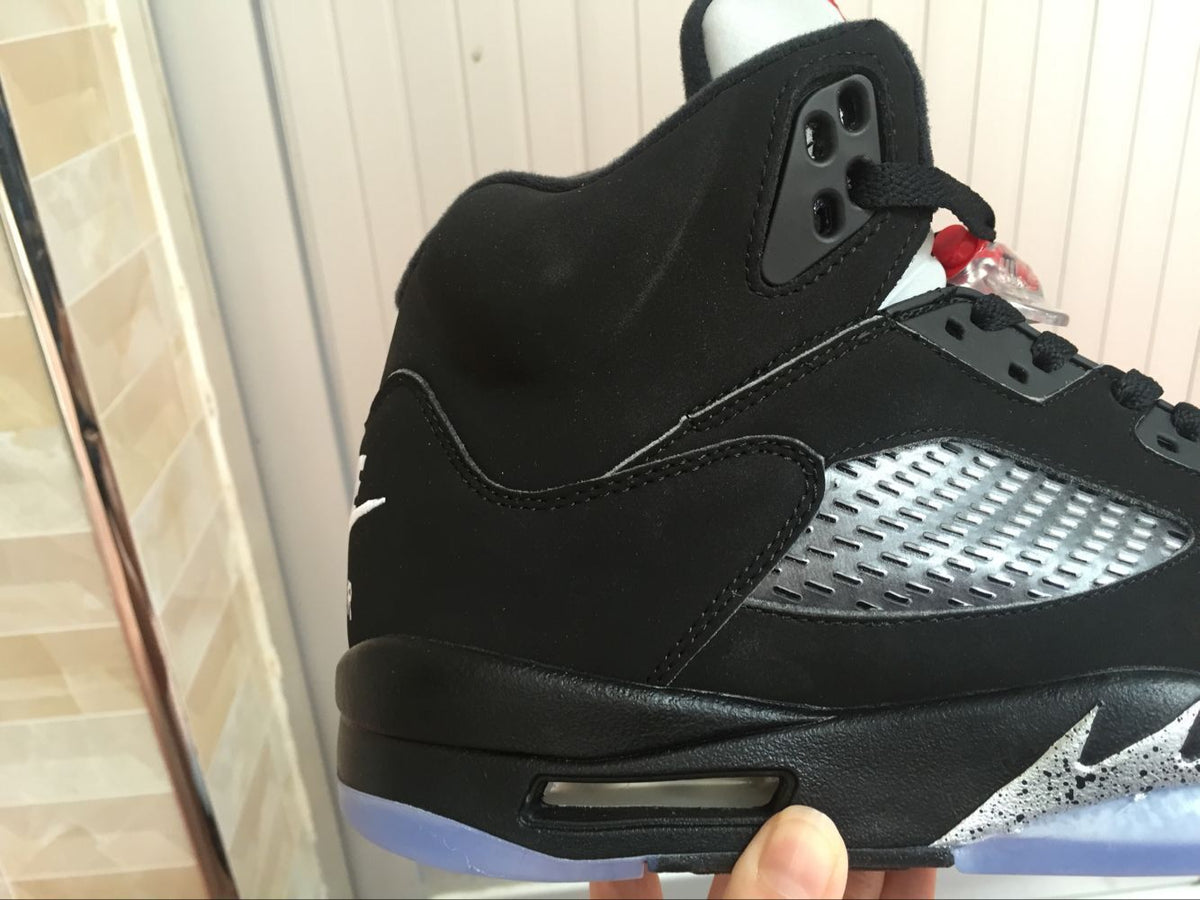 Close-up of the black upper, silver side panel, ankle padding, and visible outsole window.