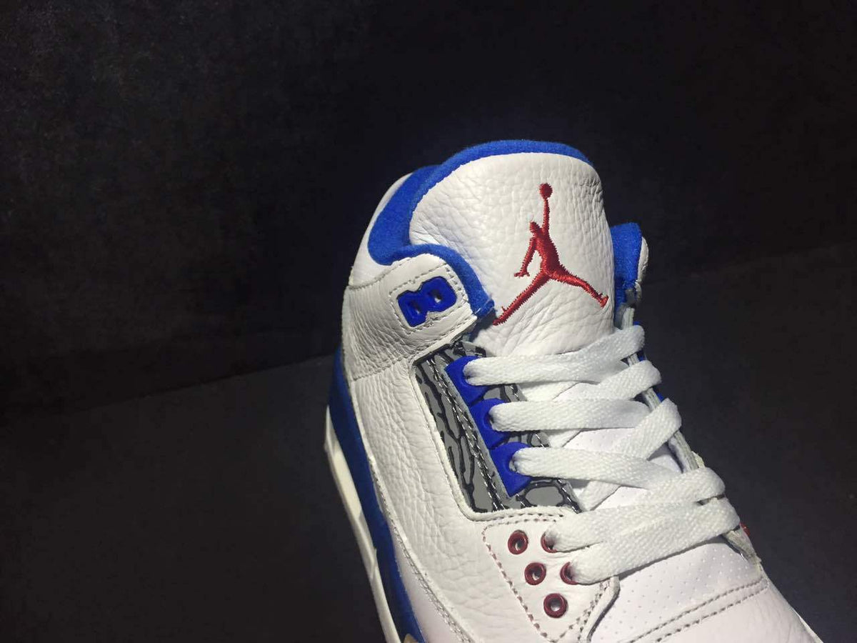 Close-up of the tongue with red Jumpman branding, white laces, blue trim, and red eyelets.