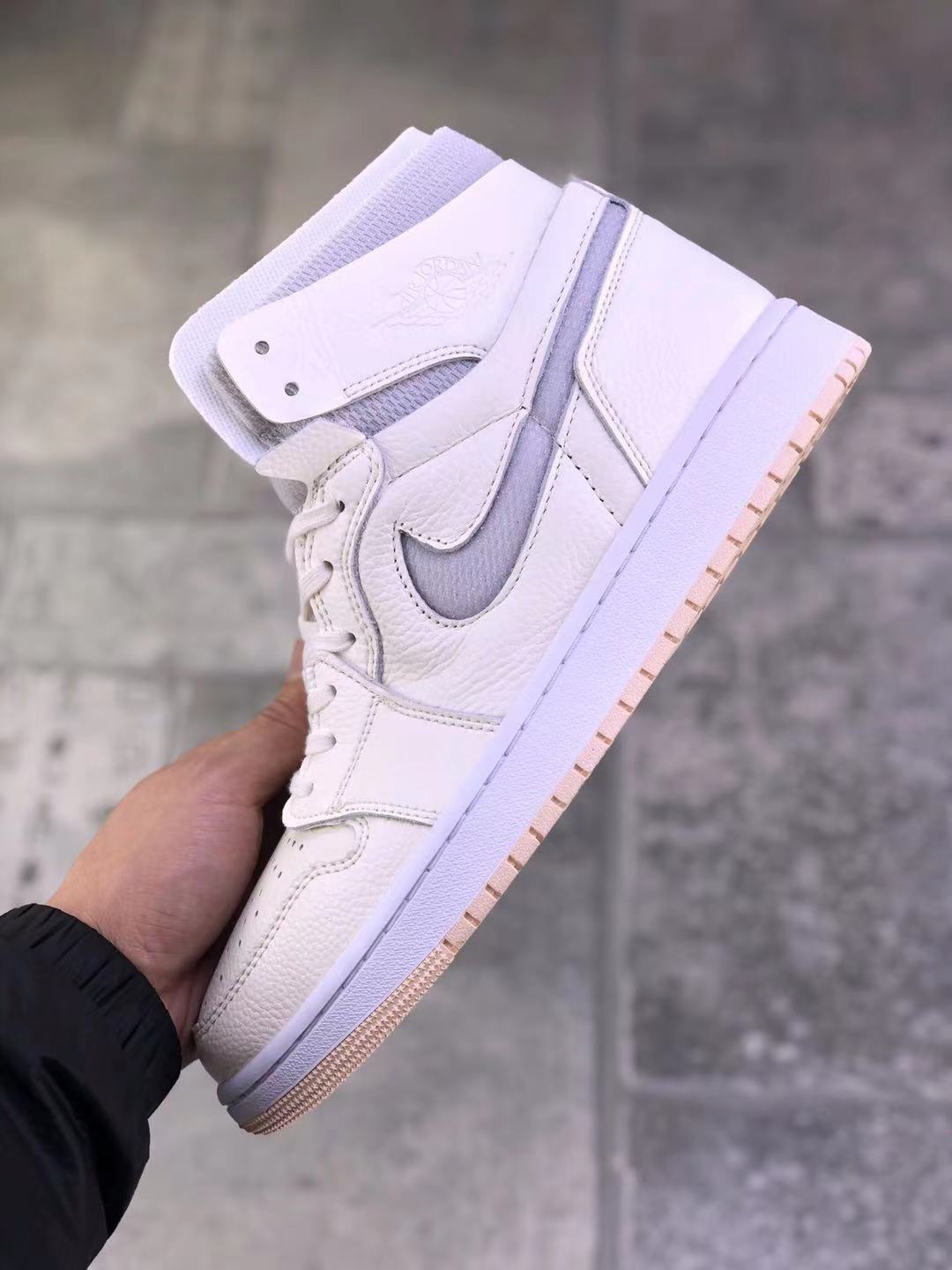 Angled side view of the pearl white high-top sneaker showing the gray side accent, ankle panel, and pale pink outsole.