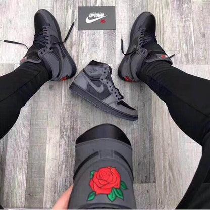 Lifestyle view of the sneakers being worn, with the rose heel embroidery visible.