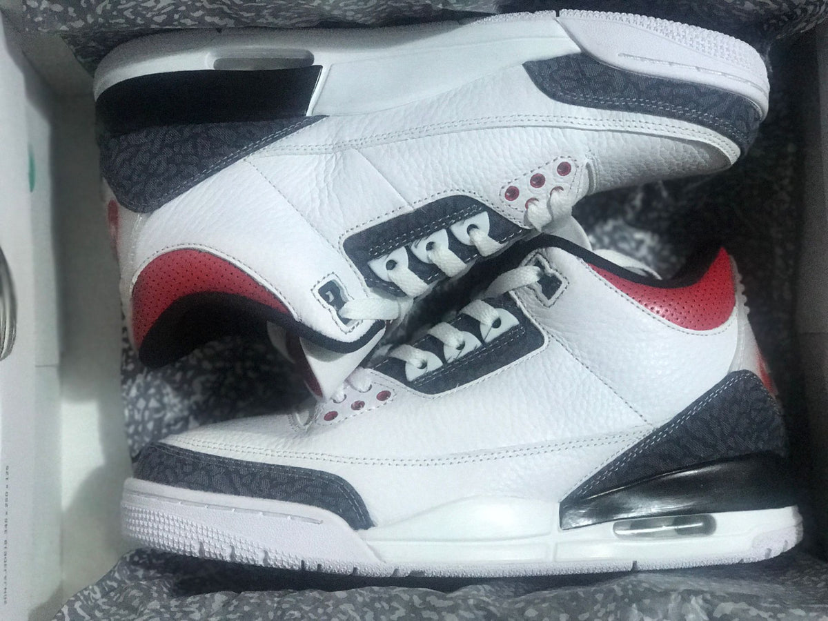 Pair of white, black, and red Jordan 3 Retro SE sneakers in the box