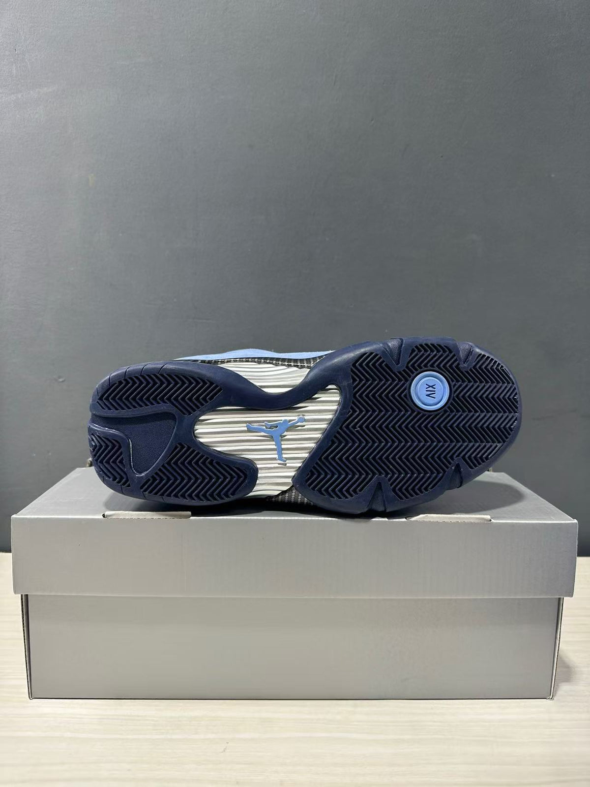 Jordan Air Jordan 14 sneaker shown from below with a patterned outsole and visible Jordan logo.