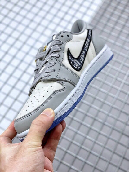 Angled close-up showing grey overlays, white perforated toe panel, patterned black Swoosh, and grey laces.