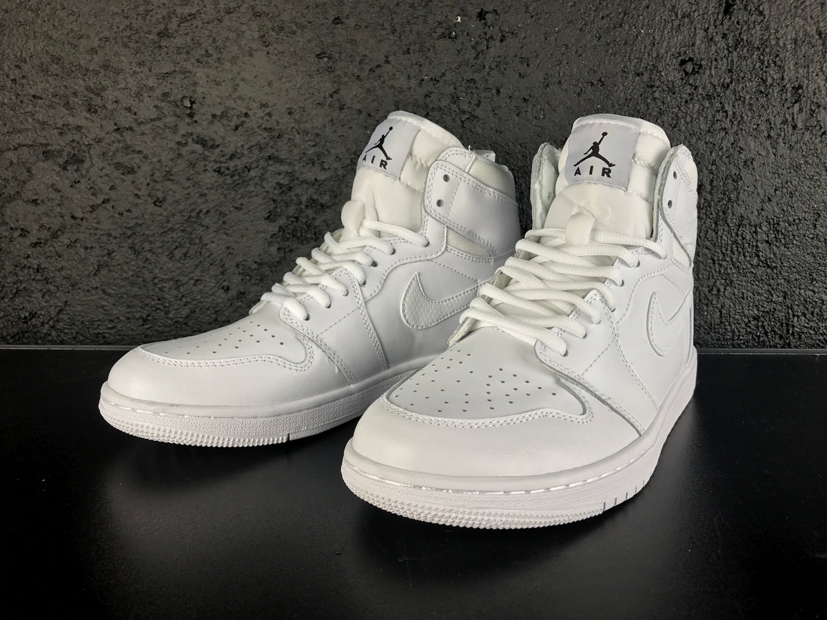Front three-quarter product view of the white pair with Jordan tongue labels, laces and perforated toe boxes.