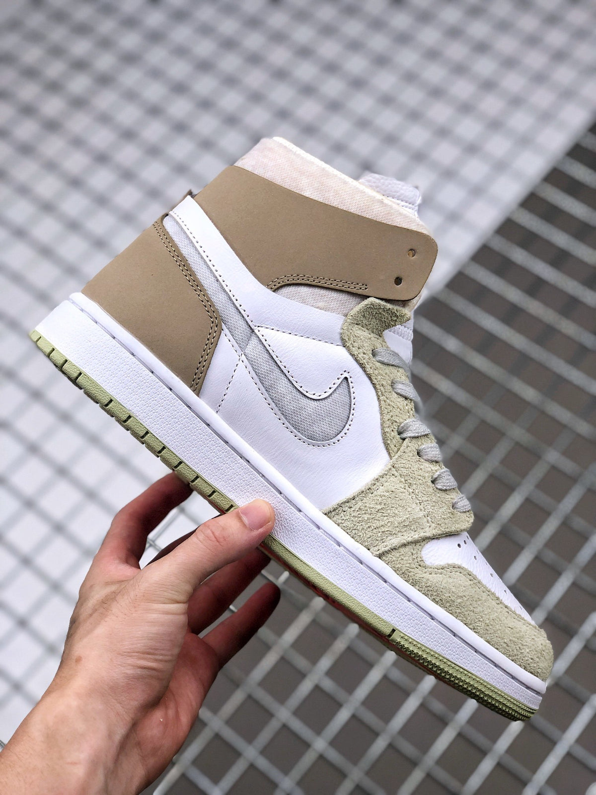 Side profile of the high-top sneaker showing layered white and brown panels, gray Swoosh, and olive green outsole.