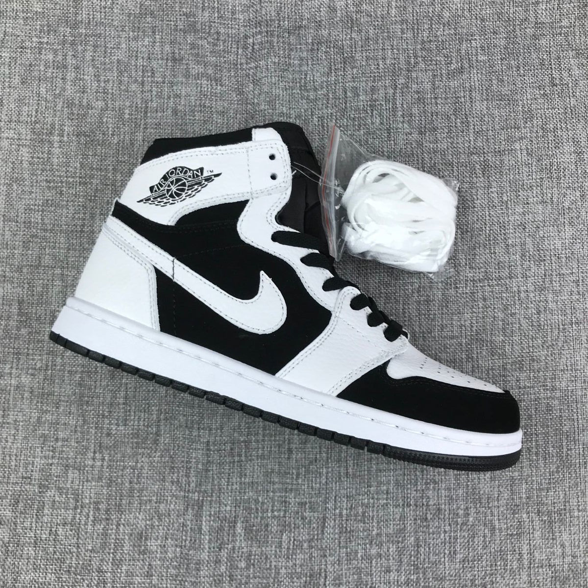 Angled view of one sneaker with an extra set of white laces