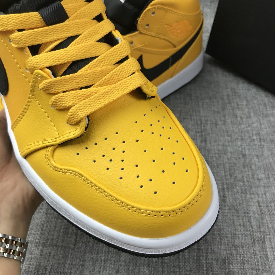 Close-up of the yellow perforated toe box, laces, and stitching.