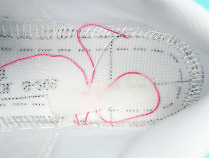 Close-up of the white shoe interior showing stitched lining and pink-and-white detailing.