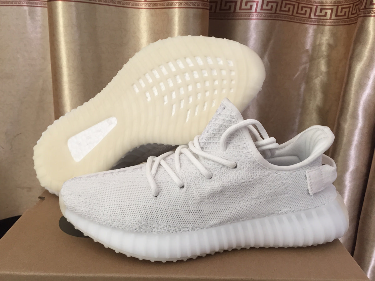 Side view of a white sneaker beside another shoe turned to show the textured outsole.