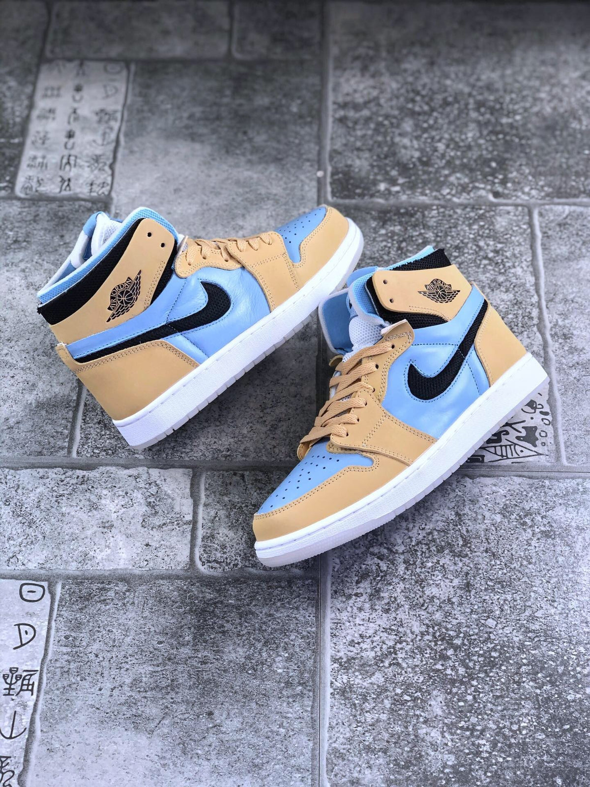 Pair of tan and light blue high-top sneakers shown from an angled top and side view.