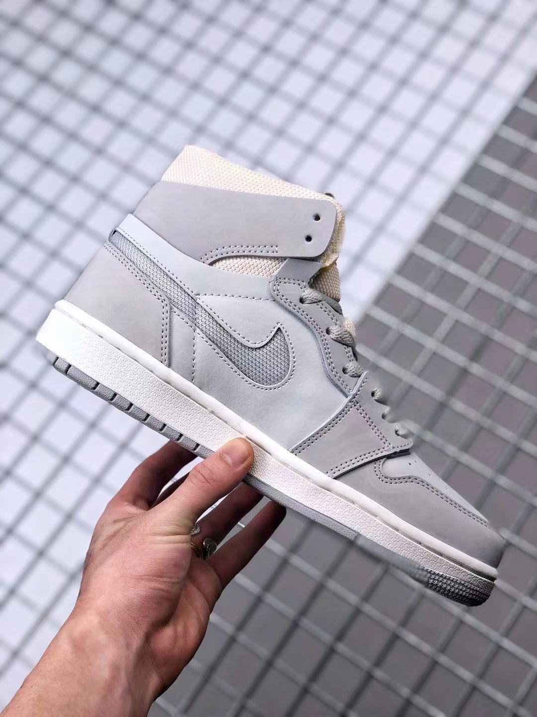 Side profile of the gray high-top sneaker showing the layered upper, Swoosh, white midsole, and gray outsole.