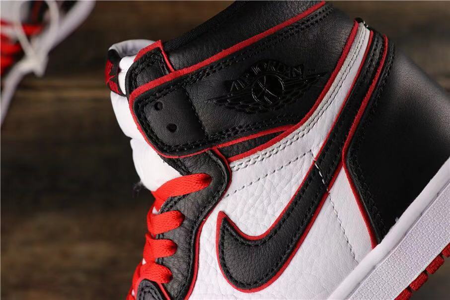 Close-up of the ankle collar, embossed wing-style branding, black overlays, white panels, and red trim.