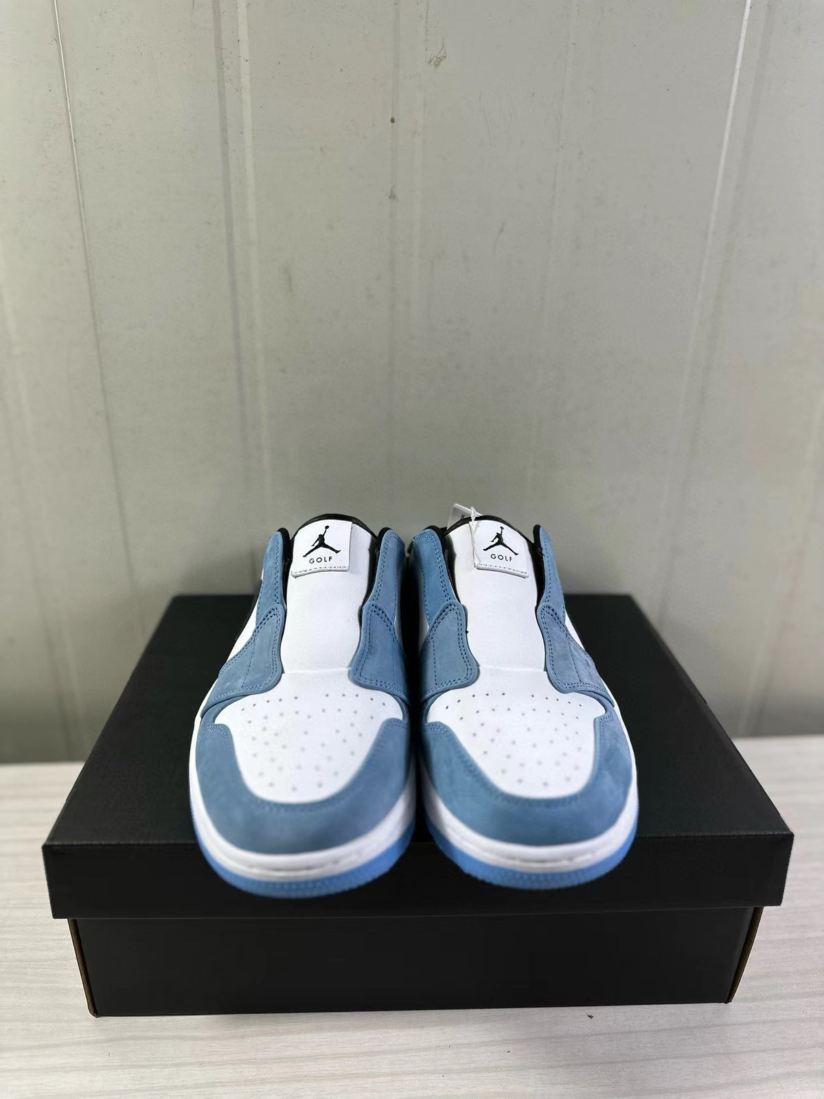 Front view of the pair showing perforated white toe areas, blue overlays, and Jordan Golf tongue branding.