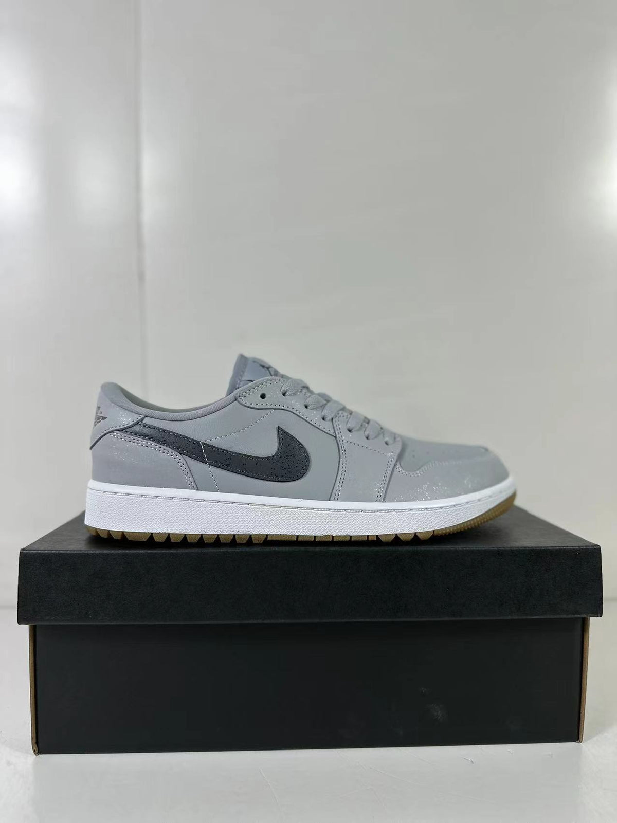 Side profile highlighting the grey upper, dark Swoosh, white midsole, and gum outsole.
