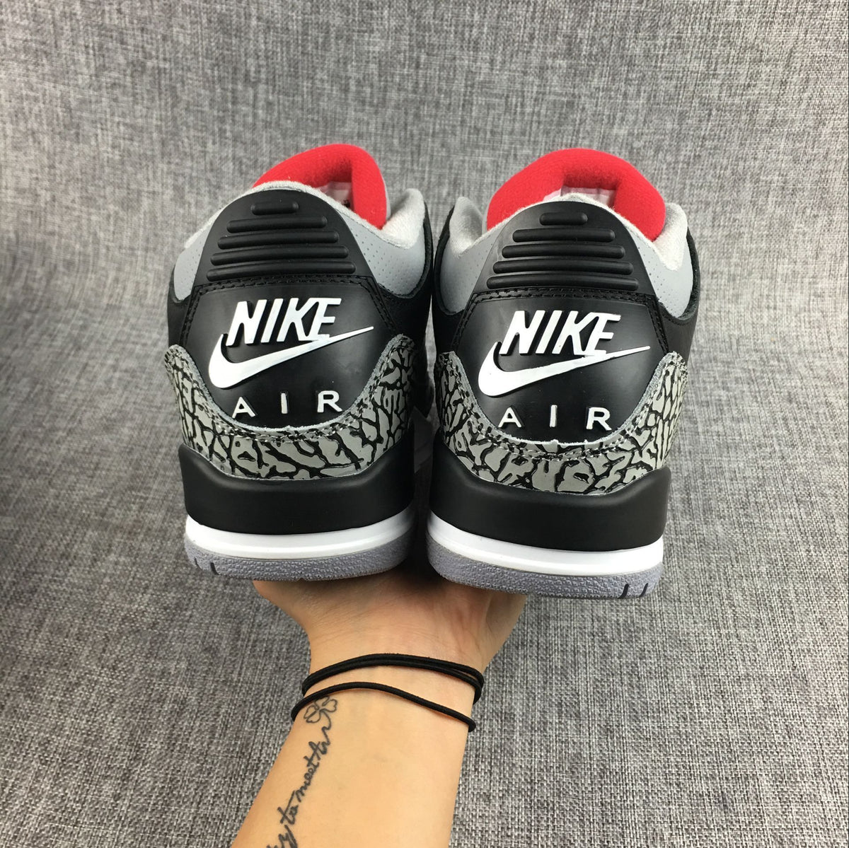 Close-up side view of a sneaker with black upper and elephant-print accents