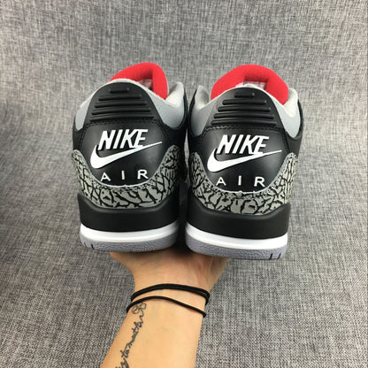 Close-up side view of a sneaker with black upper and elephant-print accents
