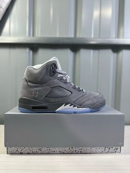 Side profile of a grey high-top sneaker showing the padded collar, stitched panels, side ventilation panel, number 23 detail, and translucent outsole.