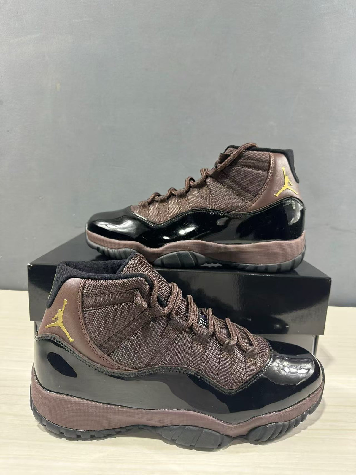 Close angled view of the black patent-style lower upper, bronze textile panels, and high-top collar.