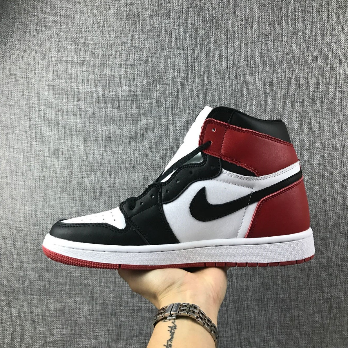 Side profile of a red, white, and black Air Jordan 1 sneaker