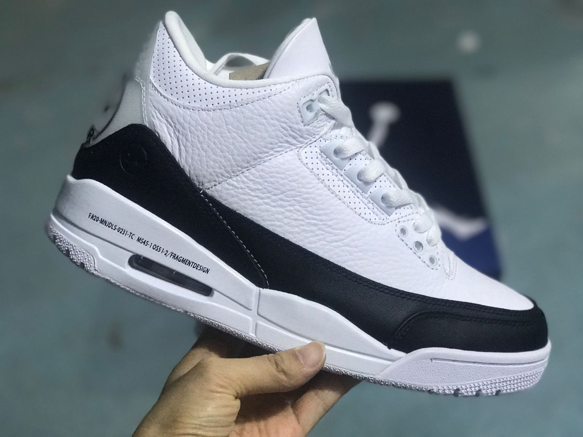 Angled view of the white and black sneaker with printed midsole text.