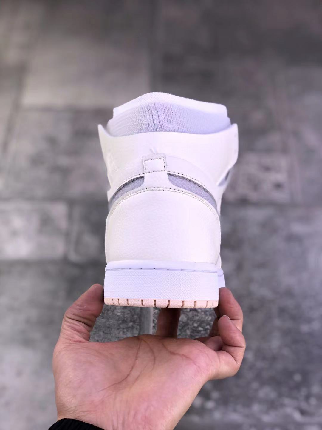 Rear view of a pearl white high-top sneaker showing the padded collar, heel construction, and pale pink outsole edge.