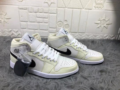 Pair of cream, white, and black mid-top sneakers shown from an angled front view, with an extra black lace accessory in a clear bag.
