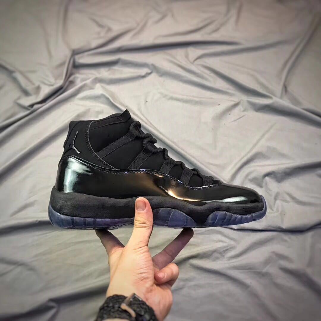 Side profile of a black high-top sneaker with glossy overlays and a translucent outsole.