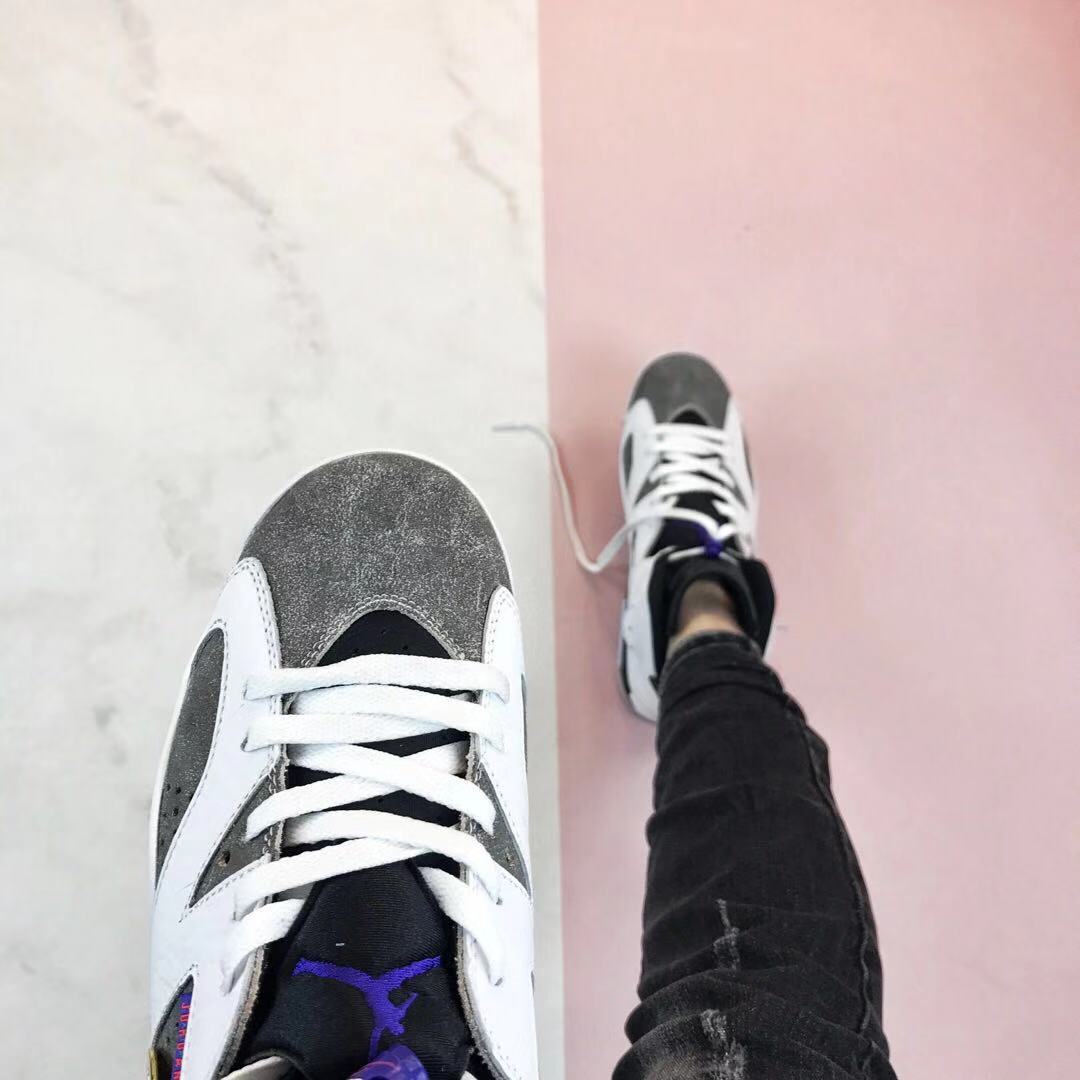 Top-down close-up showing the grey toe, white laces, black tongue, and purple tongue emblem.