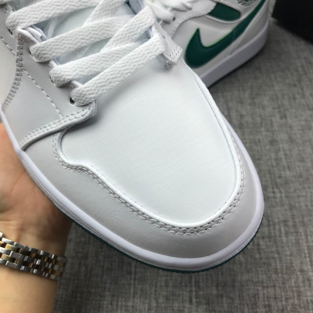 Close-up of the white toe box, white laces, and stitched panel details.