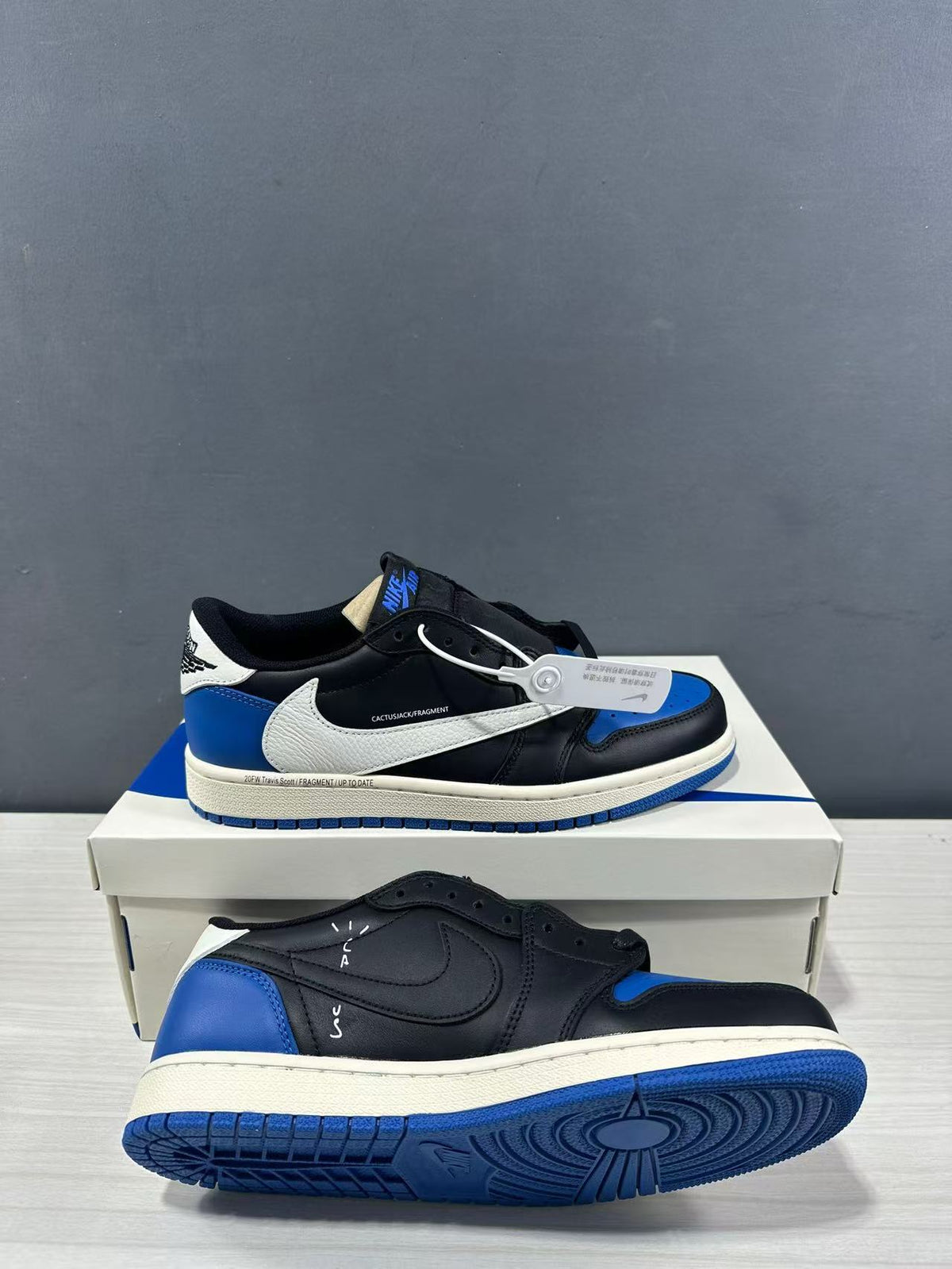 Angled product view showing the side branding, blue outsole, and a second shoe in the foreground.