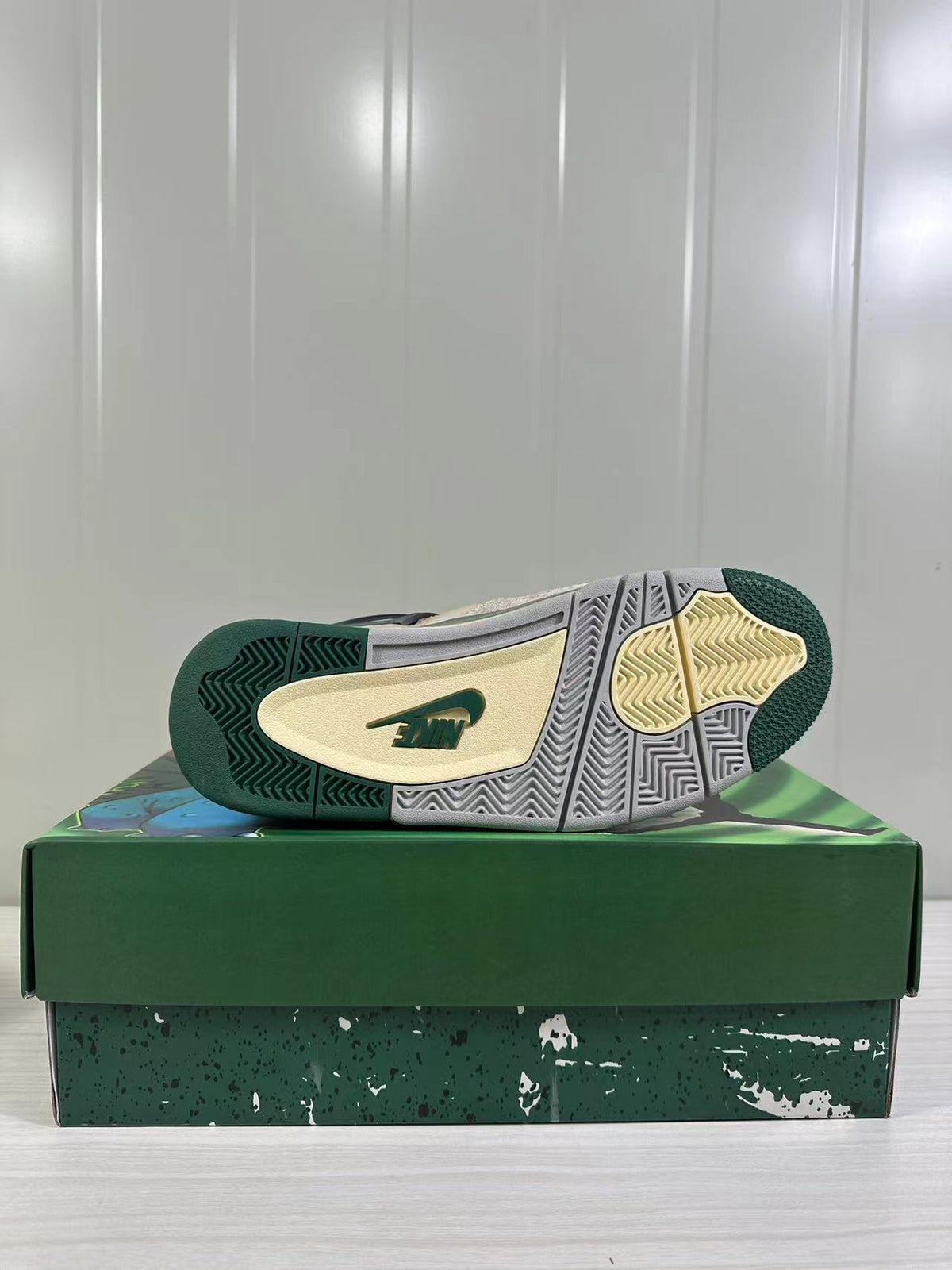 Outsole view showing green, gray and pale yellow tread sections with a visible branded insert.