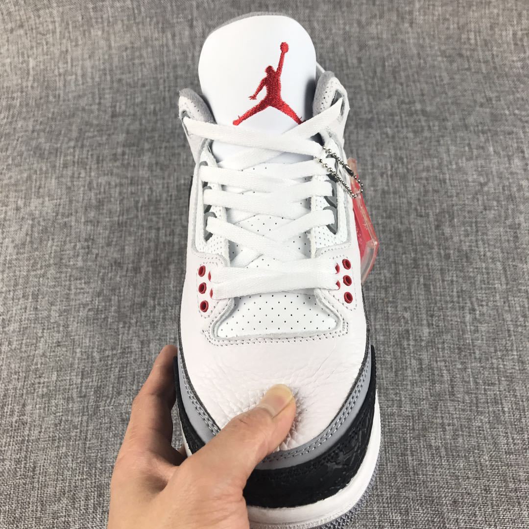 Front view showing white laces, perforated panels, grey eyelets, and red tongue branding.