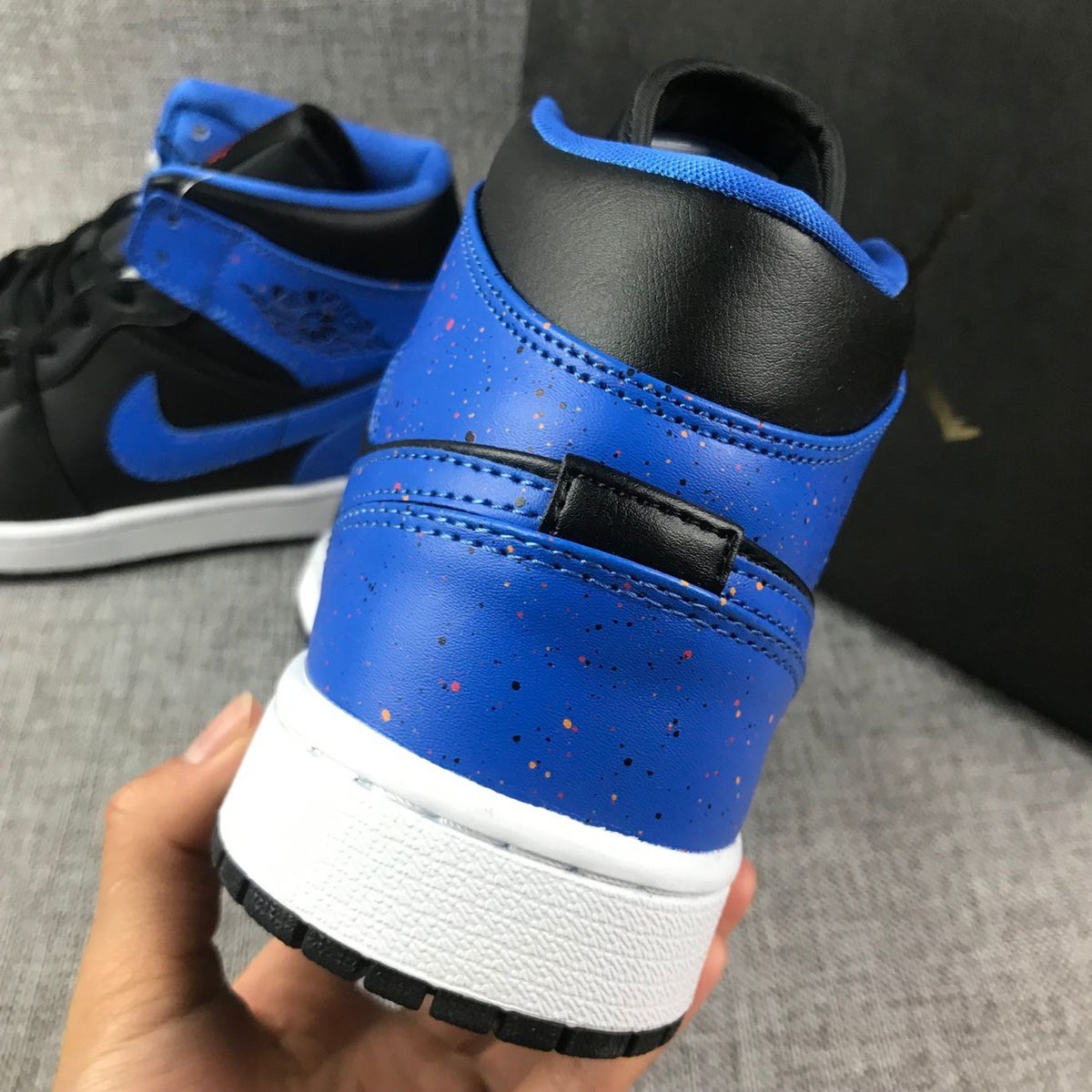 Close-up of the blue heel panel, black collar, stitching, and white midsole.