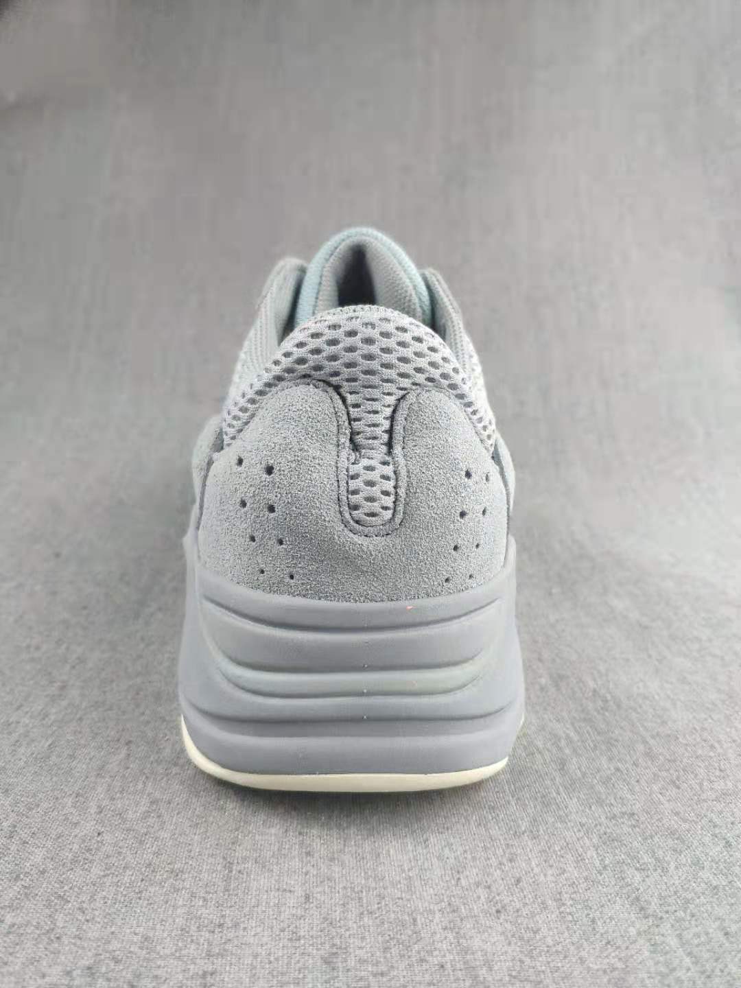 Rear view showing the padded heel, perforated upper panel, layered gray sole, and light outsole edge.