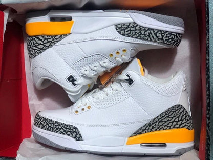 Pair of white and orange Jordan 3-style sneakers with elephant-print panels, shown in a box.