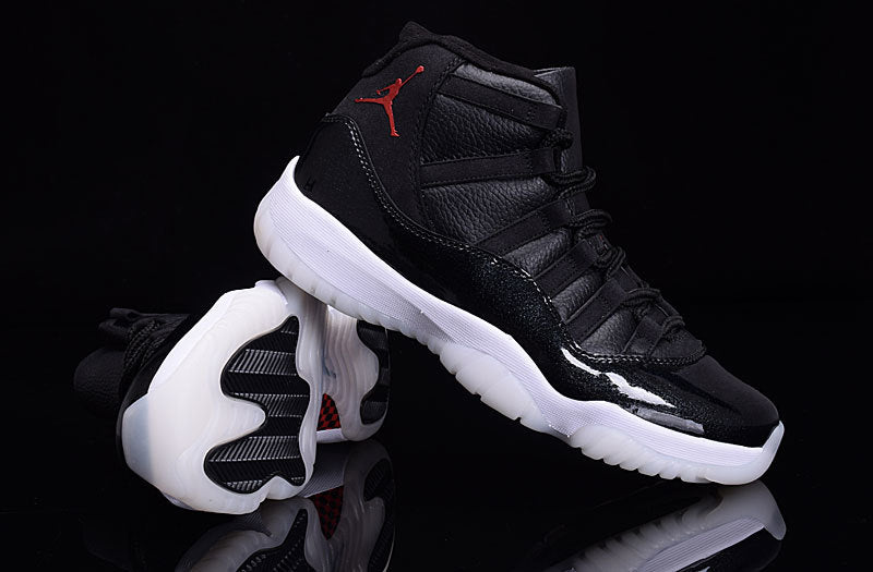 Angled view of a black high-top sneaker showing the side panels, red branding, and outsole tread.
