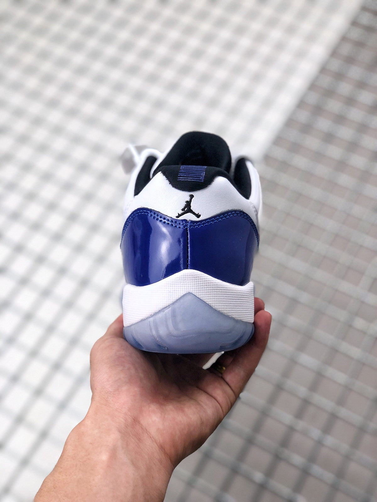 Rear view showing the blue heel overlay, white midsole, black collar, and Jordan branding.